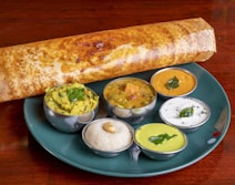 A crisp dosa served with potato masala, sambar and three chutneys